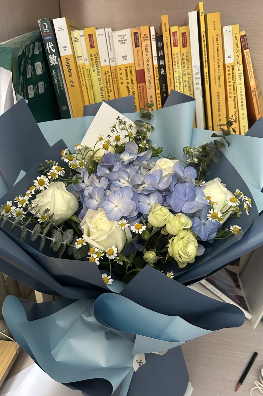 A bouquet of flowers in front of a bookshelf